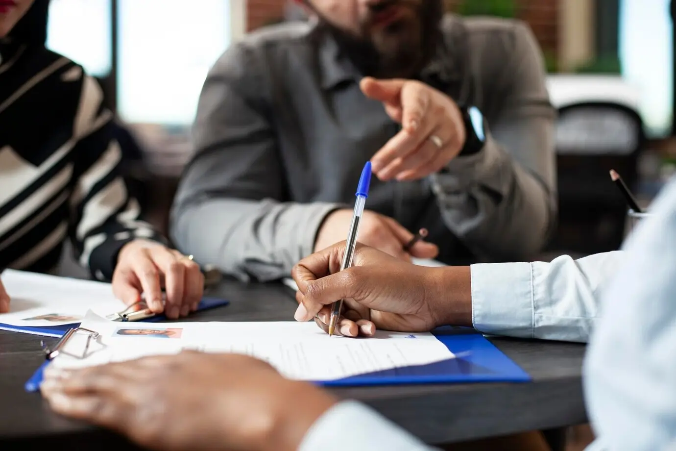 Чернокожий человек подписывает трудовой контракт.